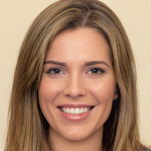 Joyful white young-adult female with long  brown hair and brown eyes