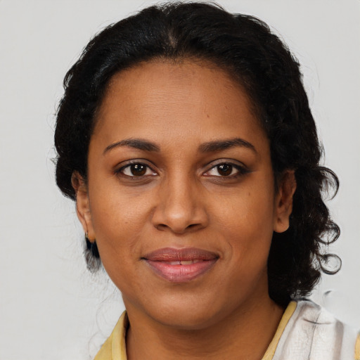 Joyful black adult female with short  brown hair and brown eyes