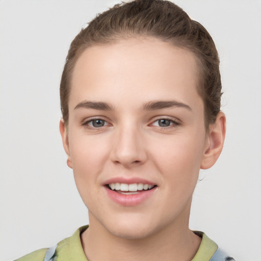 Joyful white young-adult female with short  brown hair and grey eyes