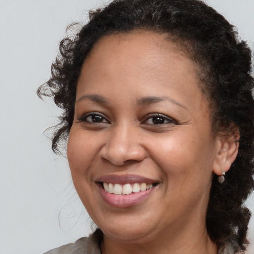 Joyful black young-adult female with medium  brown hair and brown eyes