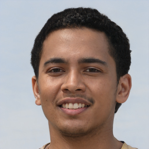 Joyful latino young-adult male with short  brown hair and brown eyes