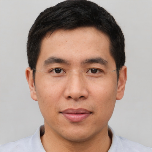 Joyful asian adult male with short  brown hair and brown eyes