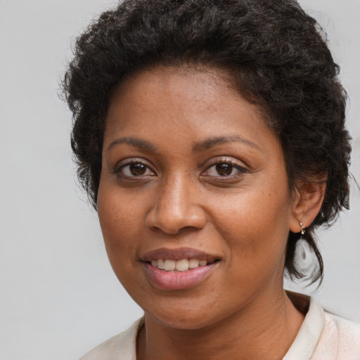 Joyful black young-adult female with short  brown hair and brown eyes
