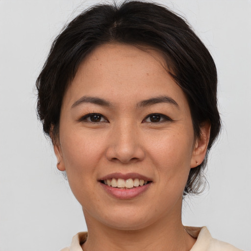 Joyful asian young-adult female with short  brown hair and brown eyes