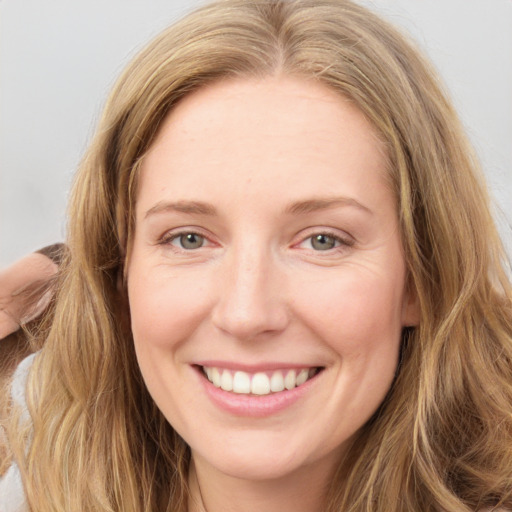 Joyful white young-adult female with long  brown hair and green eyes