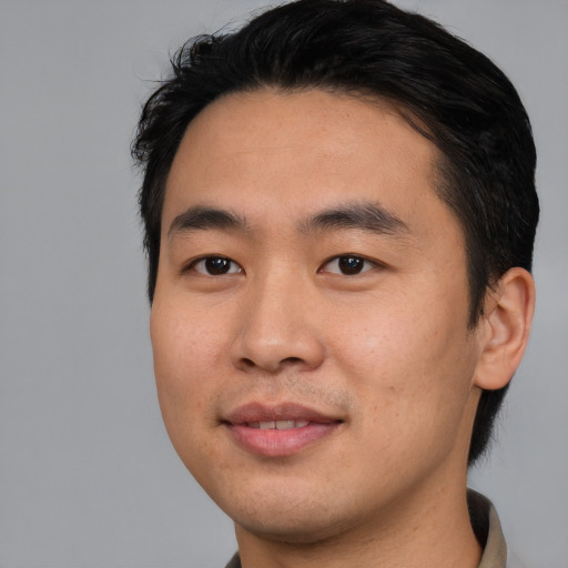 Joyful asian young-adult male with short  black hair and brown eyes