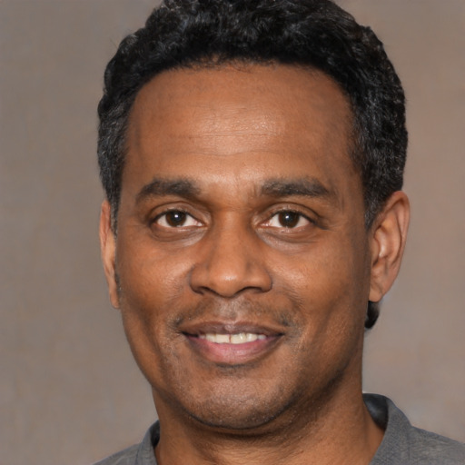 Joyful latino adult male with short  black hair and brown eyes