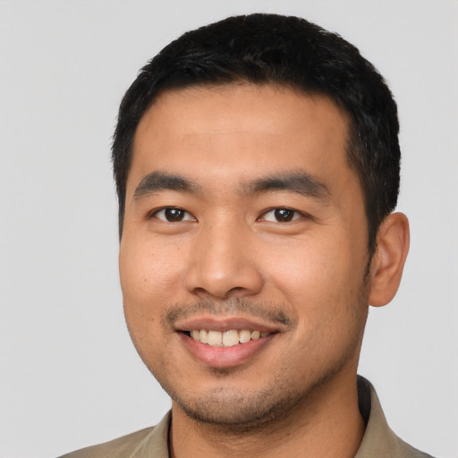 Joyful asian young-adult male with short  black hair and brown eyes