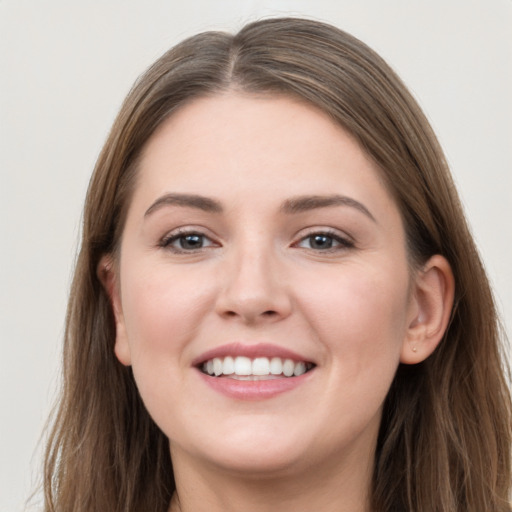 Joyful white young-adult female with long  brown hair and grey eyes