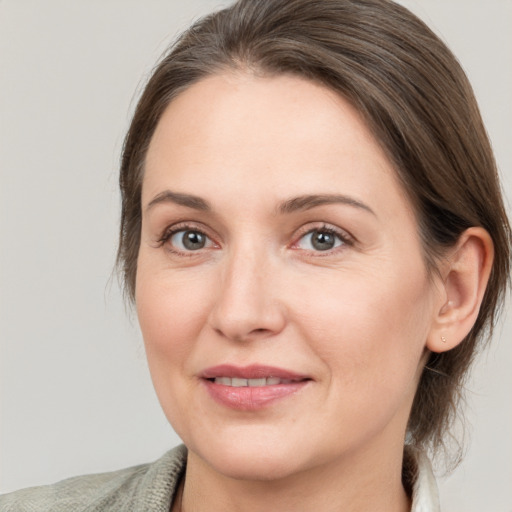 Joyful white adult female with medium  brown hair and grey eyes