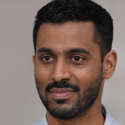 Joyful black young-adult male with short  black hair and brown eyes