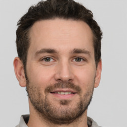 Joyful white young-adult male with short  brown hair and grey eyes