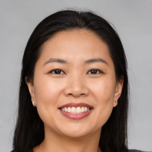 Joyful asian young-adult female with long  brown hair and brown eyes