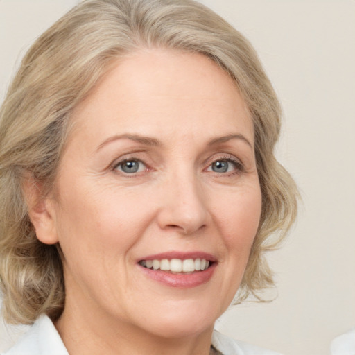 Joyful white adult female with medium  blond hair and blue eyes