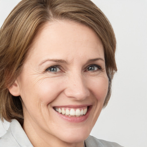 Joyful white adult female with medium  brown hair and grey eyes