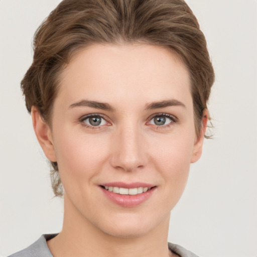 Joyful white young-adult female with short  brown hair and grey eyes