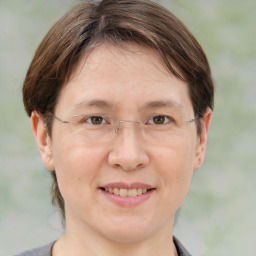 Joyful white adult female with medium  brown hair and grey eyes