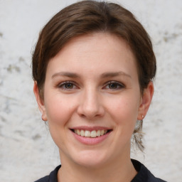 Joyful white young-adult female with medium  brown hair and grey eyes