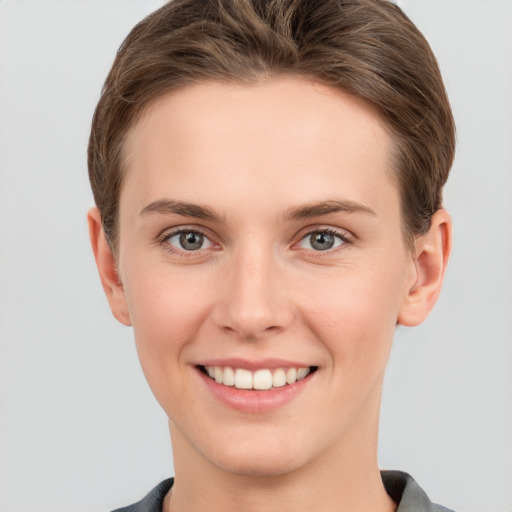 Joyful white young-adult female with short  brown hair and grey eyes