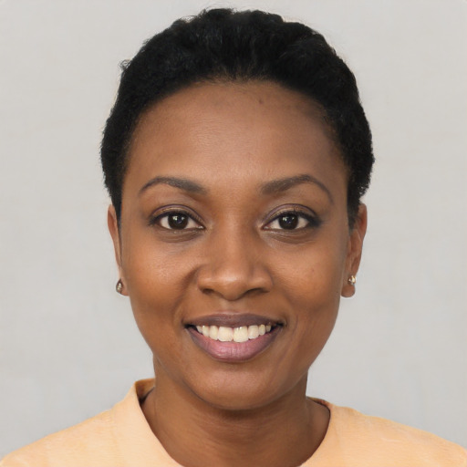 Joyful black young-adult female with short  black hair and brown eyes