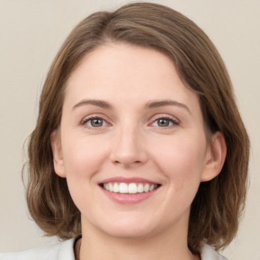 Joyful white young-adult female with medium  brown hair and green eyes