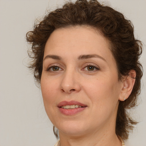 Joyful white adult female with medium  brown hair and green eyes