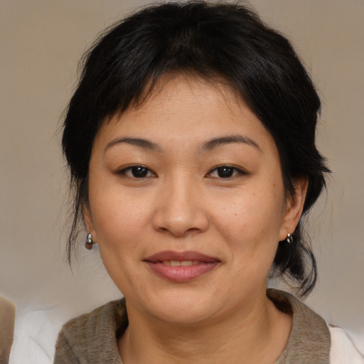 Joyful asian adult female with medium  brown hair and brown eyes