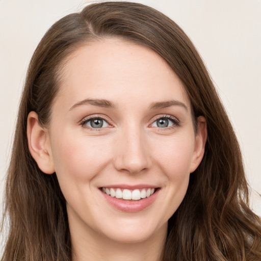 Joyful white young-adult female with long  brown hair and grey eyes