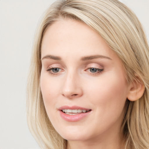 Joyful white young-adult female with long  brown hair and blue eyes