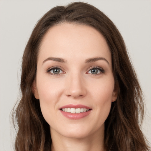 Joyful white young-adult female with long  brown hair and grey eyes