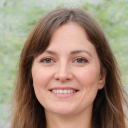 Joyful white young-adult female with long  brown hair and green eyes