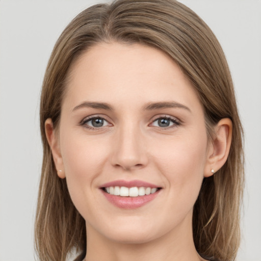 Joyful white young-adult female with long  brown hair and grey eyes