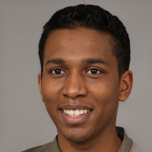 Joyful black young-adult male with short  black hair and brown eyes