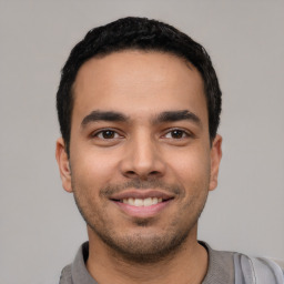 Joyful latino young-adult male with short  black hair and brown eyes