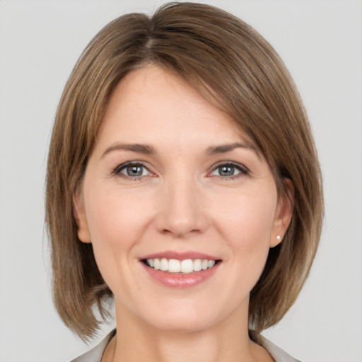 Joyful white young-adult female with medium  brown hair and grey eyes