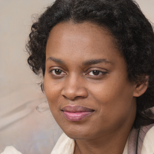 Joyful black young-adult female with long  brown hair and brown eyes