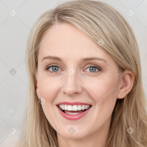 Joyful white young-adult female with long  brown hair and blue eyes