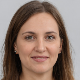 Joyful white adult female with long  brown hair and brown eyes