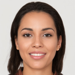 Joyful white young-adult female with long  brown hair and brown eyes