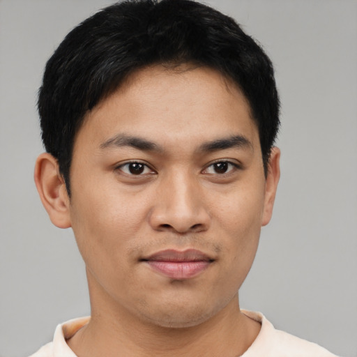 Joyful latino young-adult male with short  black hair and brown eyes