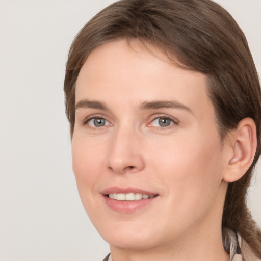 Joyful white young-adult female with medium  brown hair and grey eyes