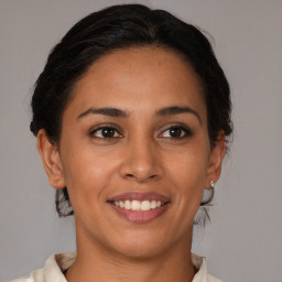 Joyful latino young-adult female with medium  brown hair and brown eyes