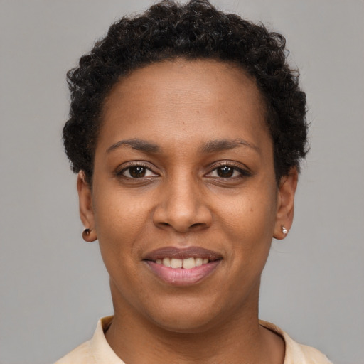Joyful black young-adult female with short  brown hair and brown eyes