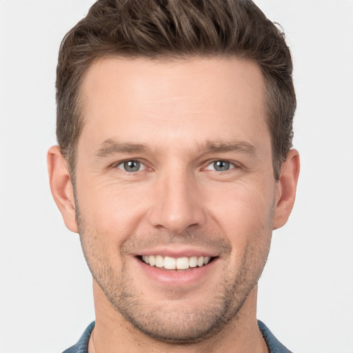 Joyful white young-adult male with short  brown hair and grey eyes