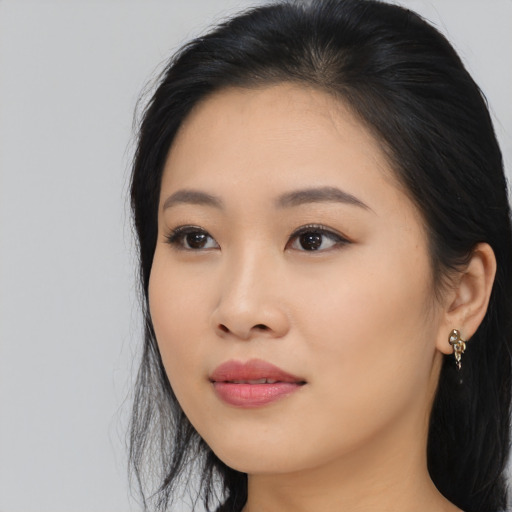Joyful asian young-adult female with long  black hair and brown eyes