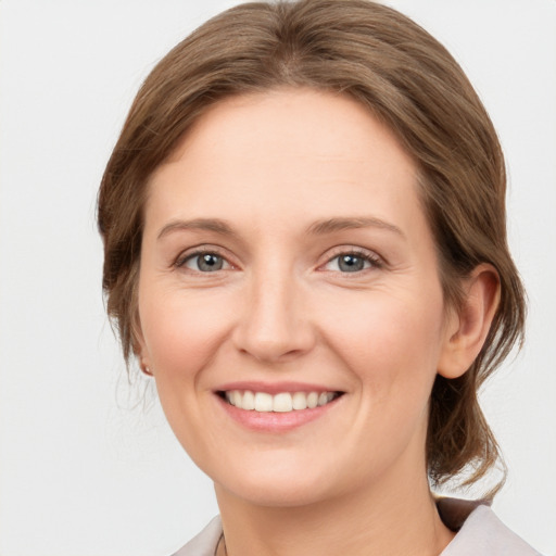 Joyful white young-adult female with medium  brown hair and grey eyes