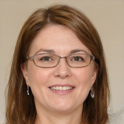 Joyful white adult female with medium  brown hair and blue eyes