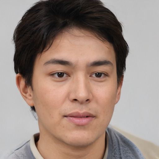 Joyful asian young-adult male with short  brown hair and brown eyes