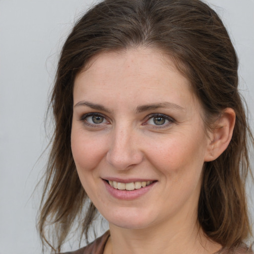 Joyful white young-adult female with medium  brown hair and grey eyes