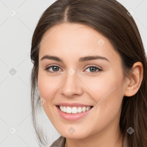 Joyful white young-adult female with long  brown hair and brown eyes